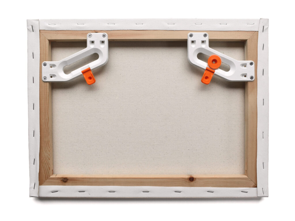 wallCLIXX picture hanging hardware being installed onto the back of canvas and framed artwork